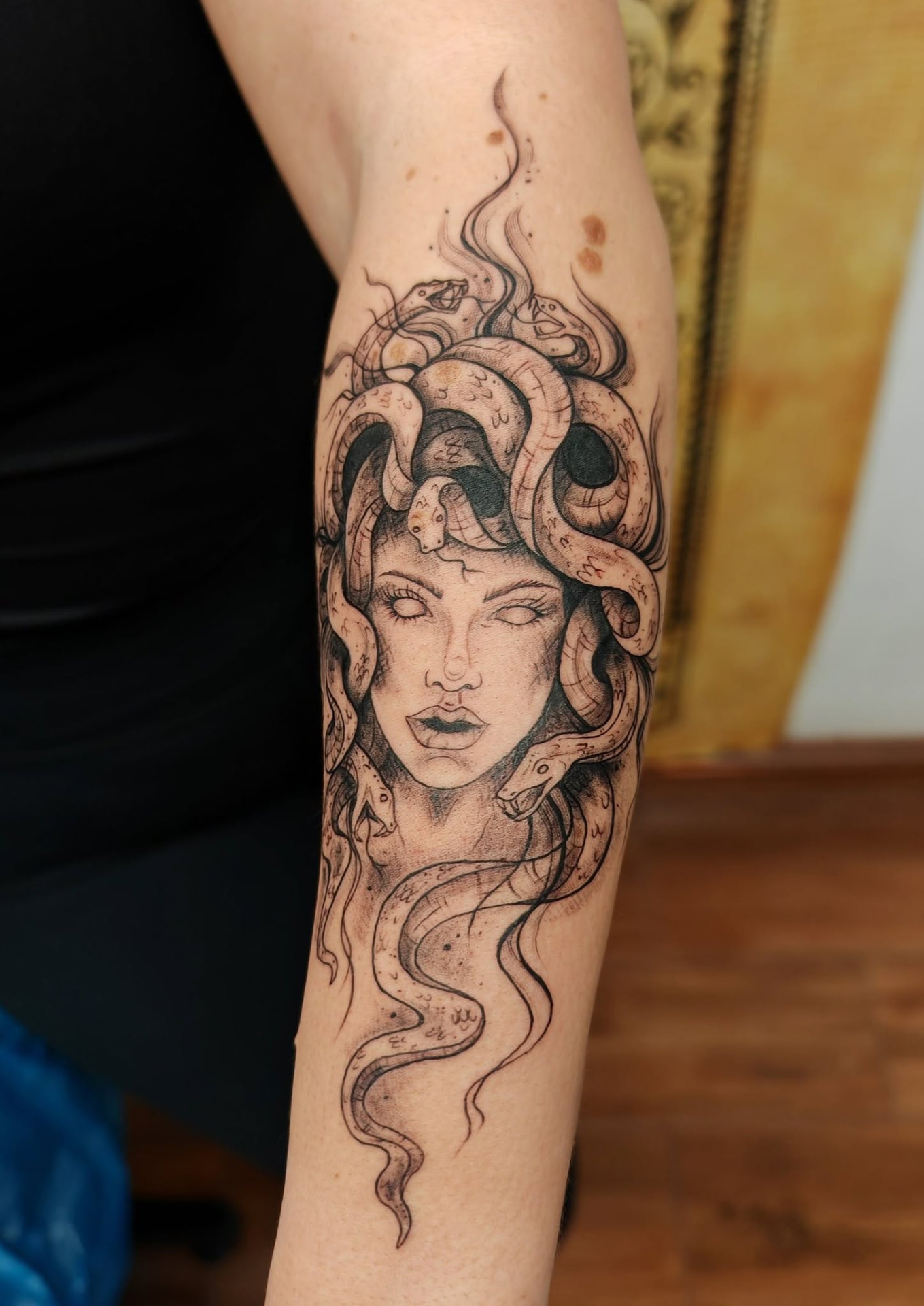 Detailní black-and-grey tetování Medusy s hady na předloktí
